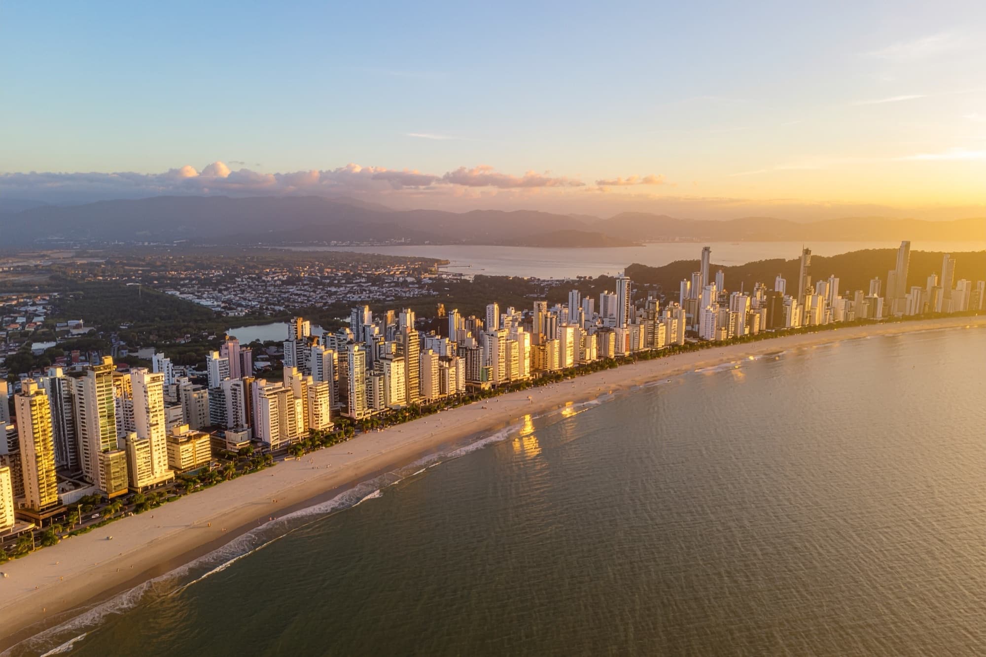 Vista aérea do skyline de Balneário Camboriú ao entardecer, orla e prédios altos
